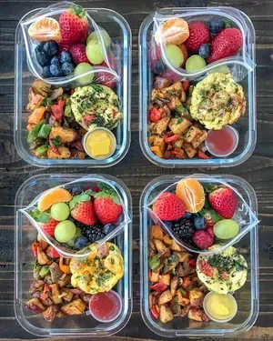 Contenitori di vetro con pasti pronti e frutta fresca